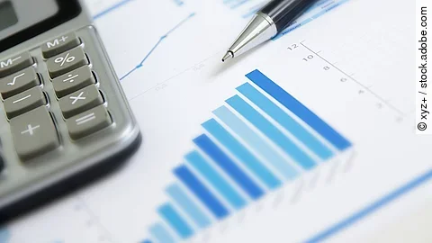 Ein Blatt Papier worauf ein Balkendiagramm abgebildet ist. Daneben liegt ein Tasschenrechner.