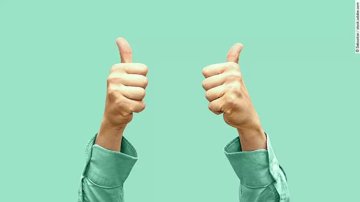 Vor türkisem Hintergrund zeigen zwei Hände Daumen nach oben.