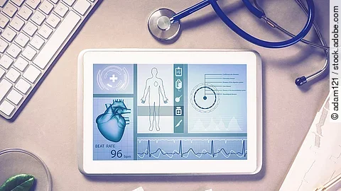 Schreibtisch mit Tablet, Stethoskop und Unterlagen