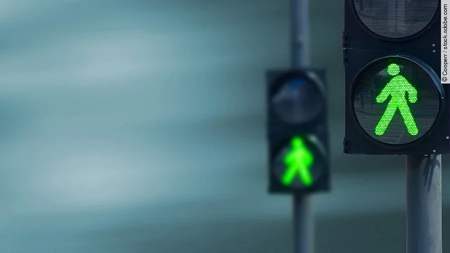 Grünes Licht Zwei Fußgängerampeln hintereinander, die beide auf grüne Ampelmännchen geschalten sind.