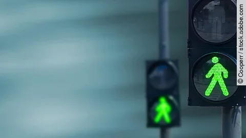Grünes Licht Zwei Fußgängerampeln hintereinander, die beide auf grüne Ampelmännchen geschalten sind.