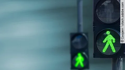 Grünes Licht Zwei Fußgängerampeln hintereinander, die beide auf grüne Ampelmännchen geschalten sind.