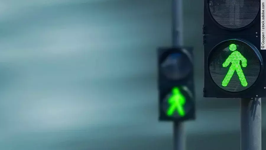 Grünes Licht Zwei Fußgängerampeln hintereinander, die beide auf grüne Ampelmännchen geschalten sind.