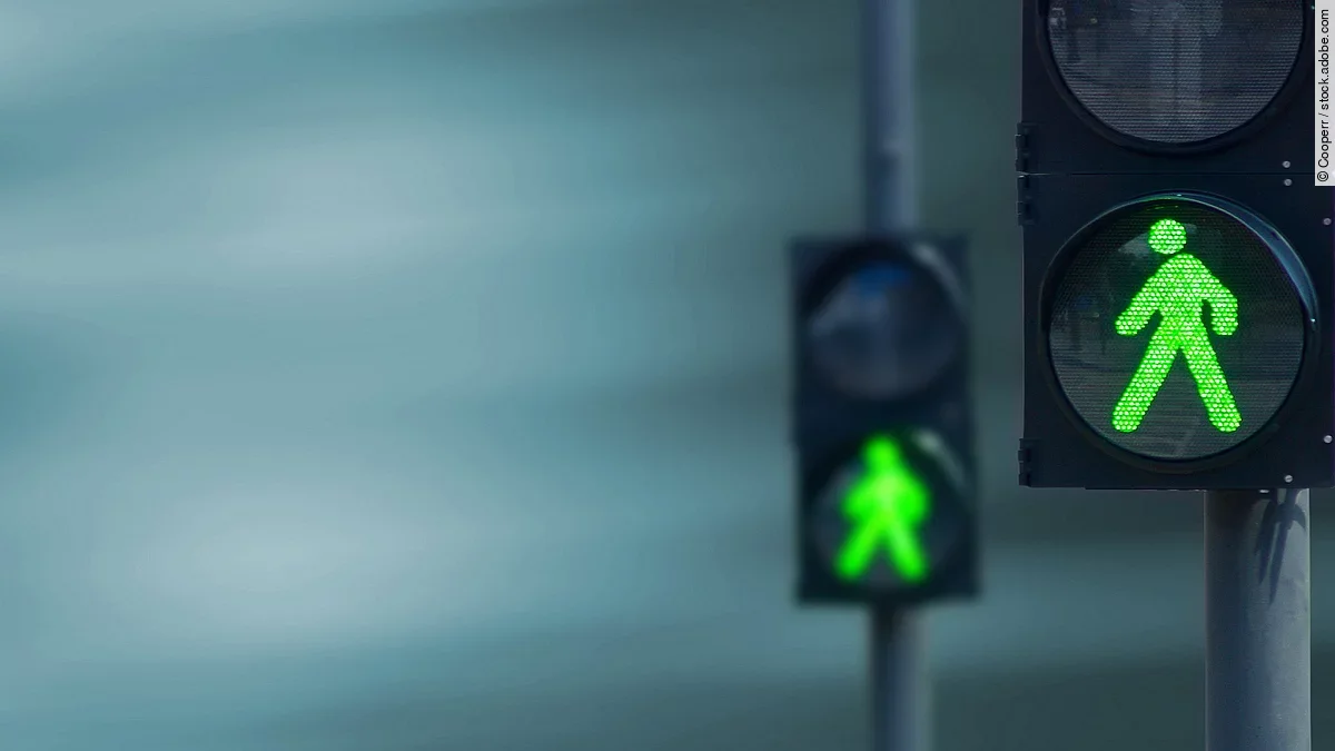 Grünes Licht Zwei Fußgängerampeln hintereinander, die beide auf grüne Ampelmännchen geschalten sind.