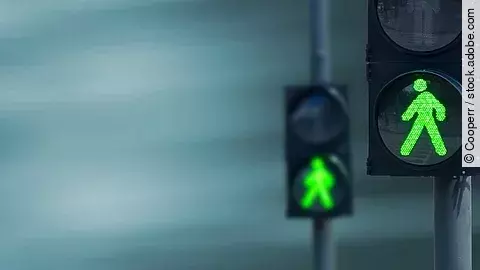 Grünes Licht Zwei Fußgängerampeln hintereinander, die beide auf grüne Ampelmännchen geschalten sind.