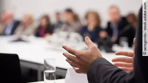 Menschen sitzen am Tisch in einer Besprechung