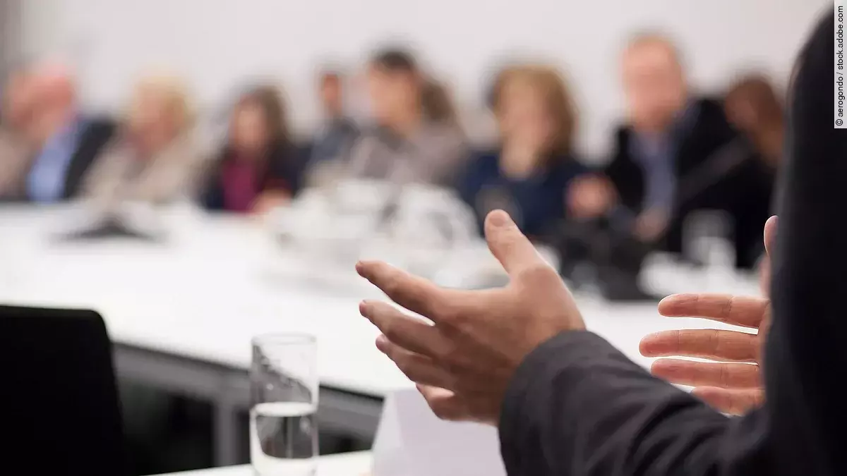 Menschen sitzen am Tisch in einer Besprechung