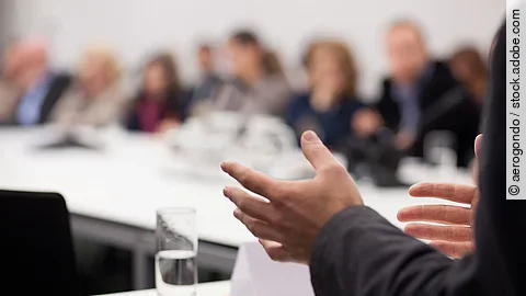 Menschen sitzen am Tisch in einer Besprechung