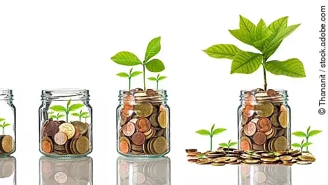 Fünf Gläser stehen nebeneinander. Das linke ist leer, das rechte gänzlich mit Münzen gefüllt. Dazwischen steigt die Menge der Münzen. Aus den Münzen wächst eine Pflanze, die mit zunehmender Geldsumme immer größer wird.