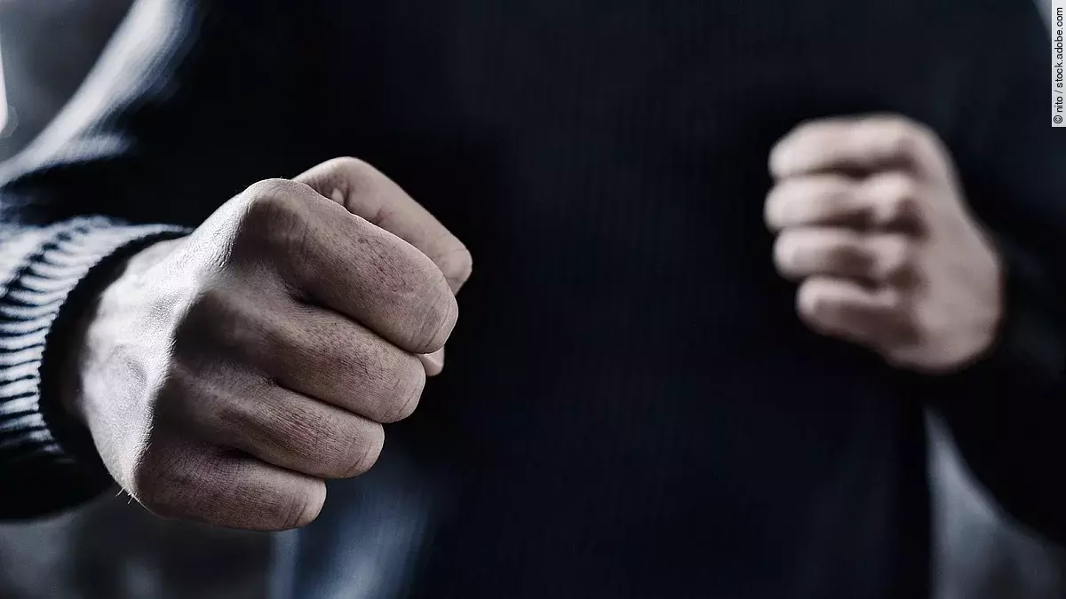 Person nimmt eine Abwehrhaltung mit geballten Fäusten ein